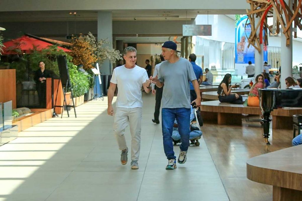 Luciano Huck e Rafael Portugal caminhando juntos em Shopping