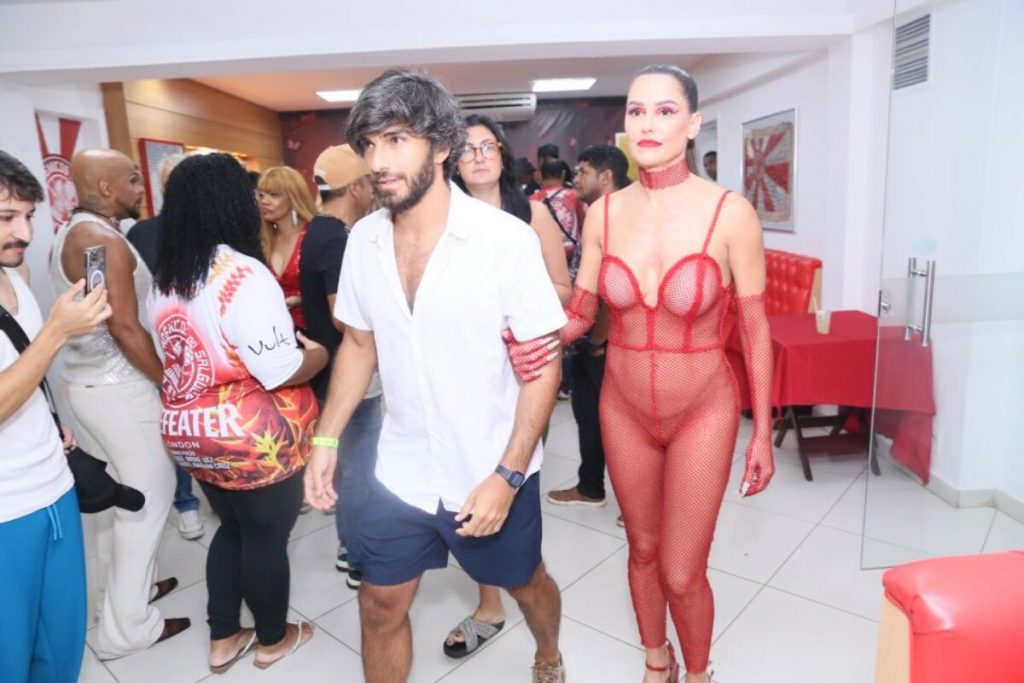 Deborah Secco de macacão de tela vermelha na quadra do Salgueiro com Hugo Moura