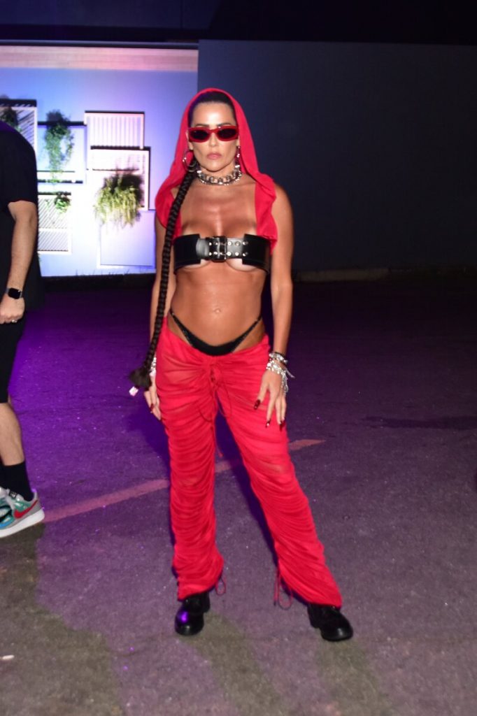 Deborah Secco de calça vermelha, gorro vermelho, top de cinto preto, calcinha preta à mostra, barriga de fora e óculos escuros