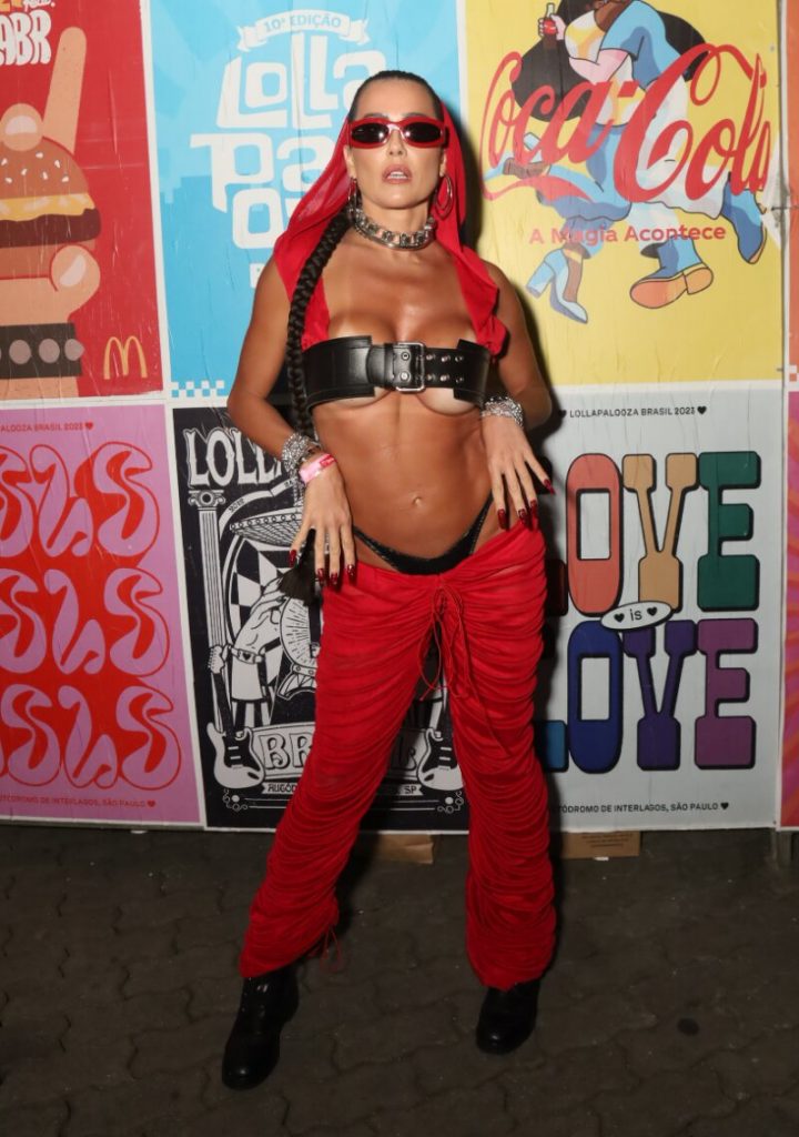 Deborah Secco de calça vermelha, gorro vermelho, top de cinto preto, calcinha preta à mostra, barriga de fora e óculos escuros