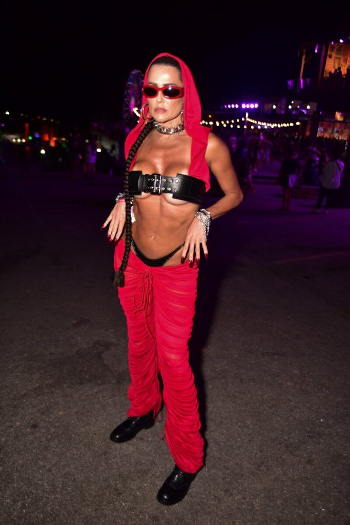 Deborah Secco de calça vermelha, gorro vermelho, top de cinto preto, calcinha preta à mostra, barriga de fora e óculos escuros