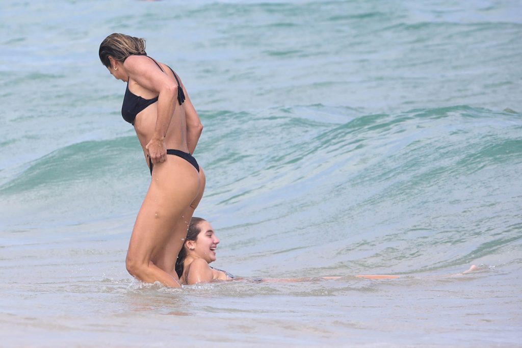 Flávia Alessandra curte banho de mar com a filha