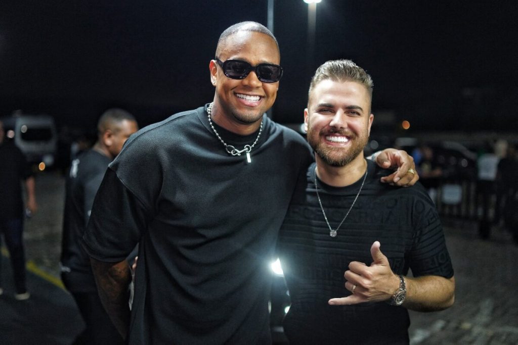 Léo Santana e Zé Netto abraçados e sorrindo 