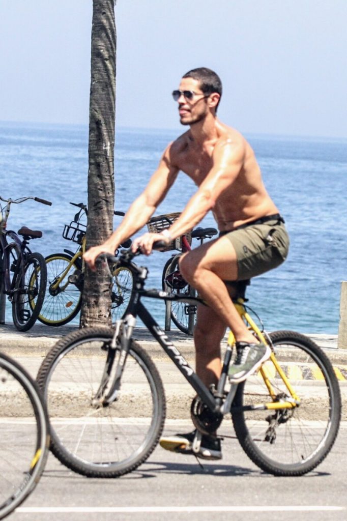 José Loreto sem camisa, andando de bicicleta na orla