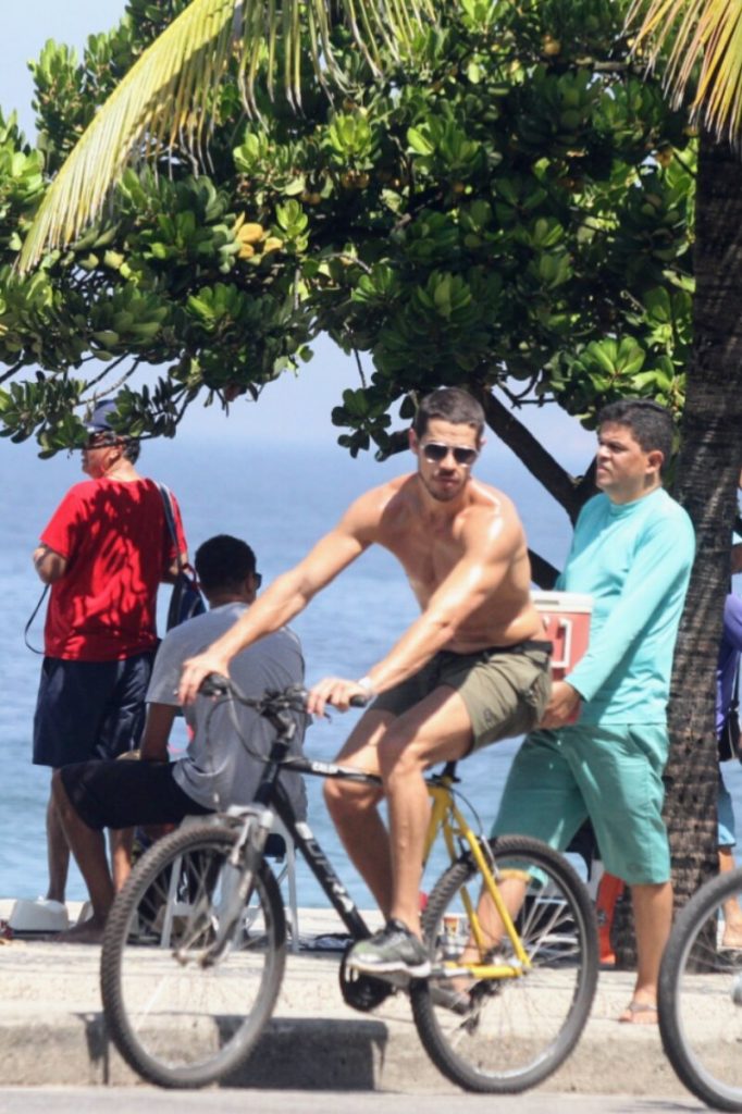 José Loreto sem camisa, andando de bicicleta na orla