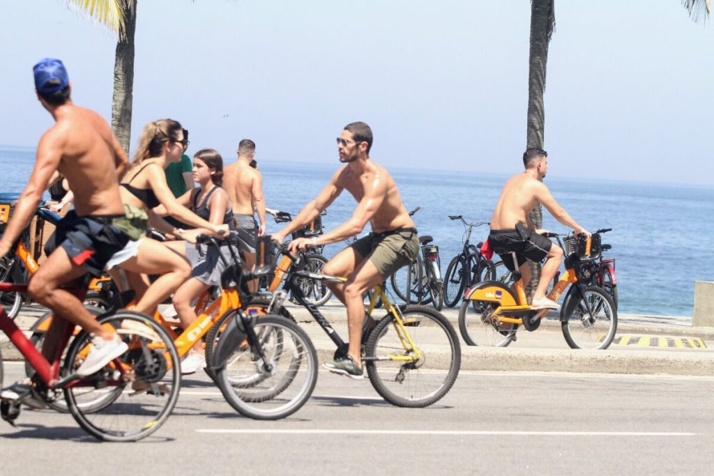 José Loreto sem camisa, andando de bicicleta na orla