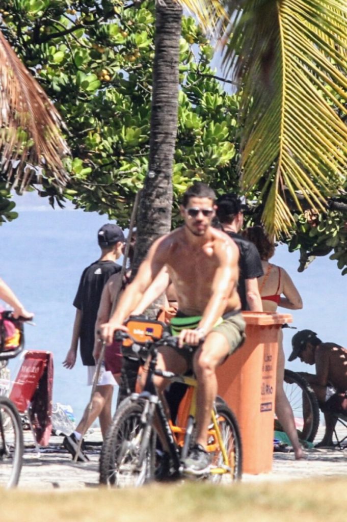 José Loreto sem camisa, andando de bicicleta na orla