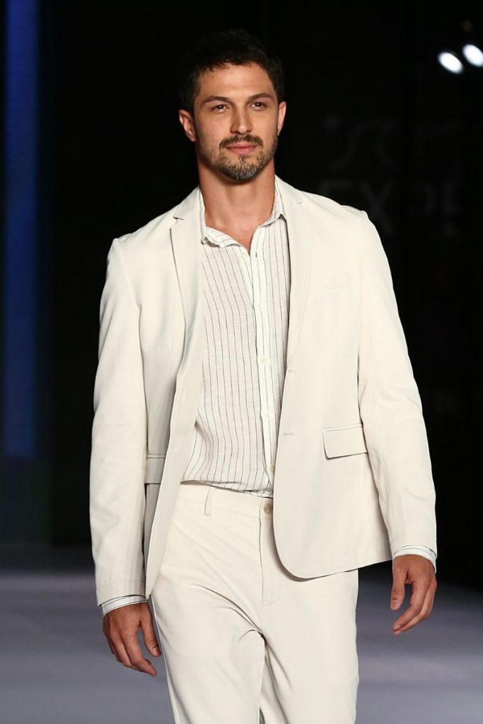 Rômulo Estrela caminha charmoso pela passarela,  em desfile