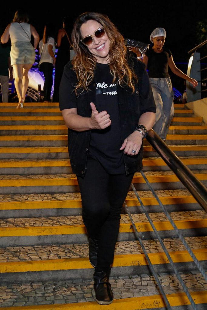 Ana Carolina de preto, fazendo sinal de positivo