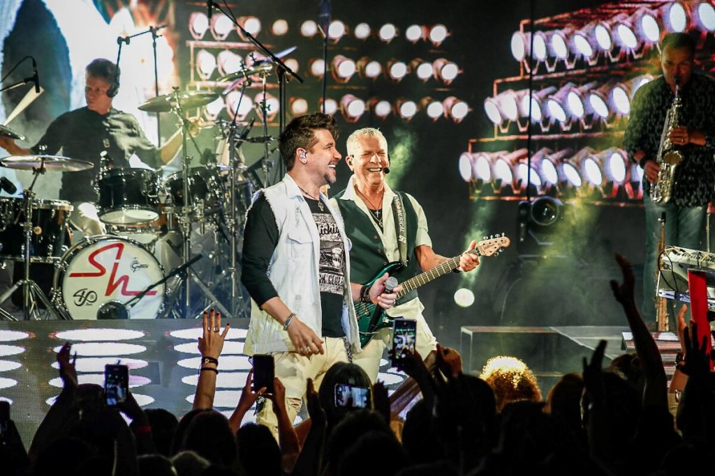 Ana Carolina toda de preto  fazendo sinal de positivo