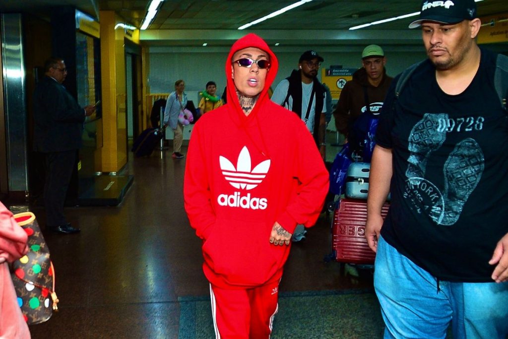 MC Daniel com blusa vermelha no aeroporto