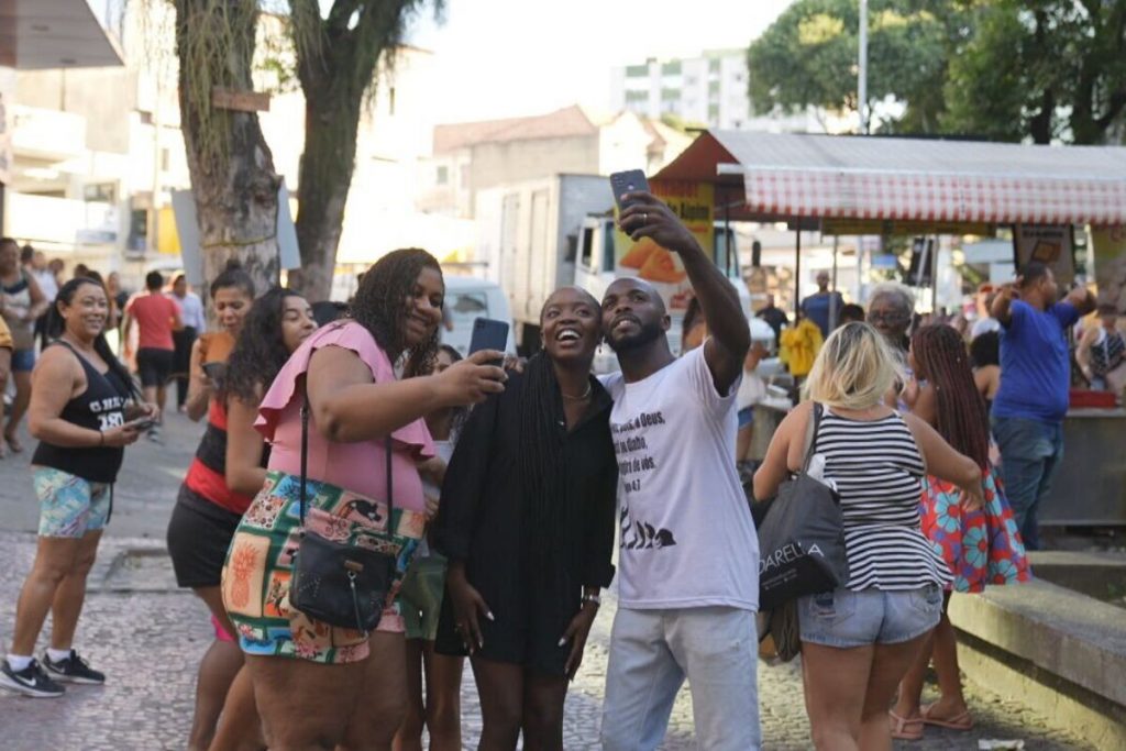 Clara Moneke com fãs na rua tirando selfie