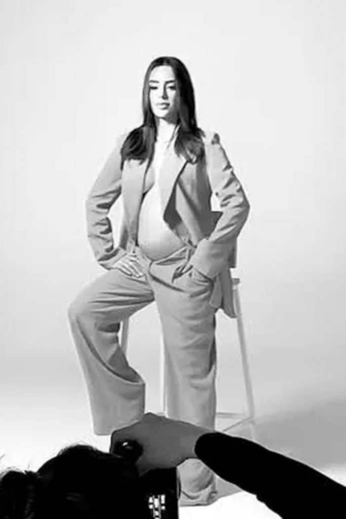 Bruna Biancardi de conjunto de alfaiataria sentada, com a barriga à mostra 