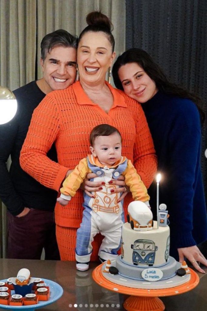 Luca se encanta com a luz da vela do bolo, enquanto mamãe, papai e irmã posam para a foto