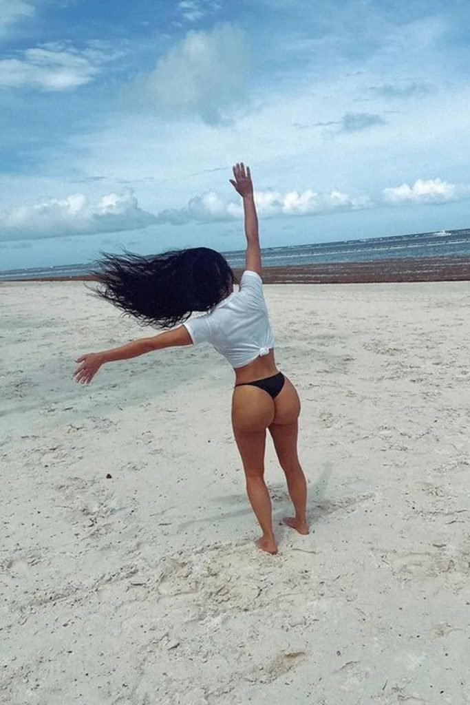 Kim Kardashian de camisa branca e biquíni preto