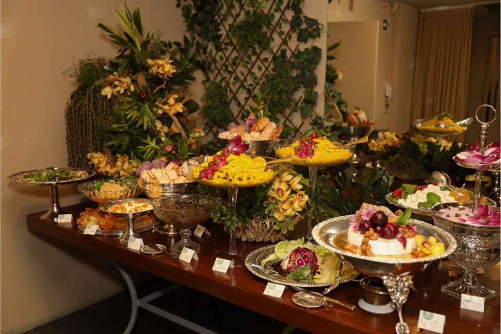 Mesa cheia de delícias da festa surpresa de Simony