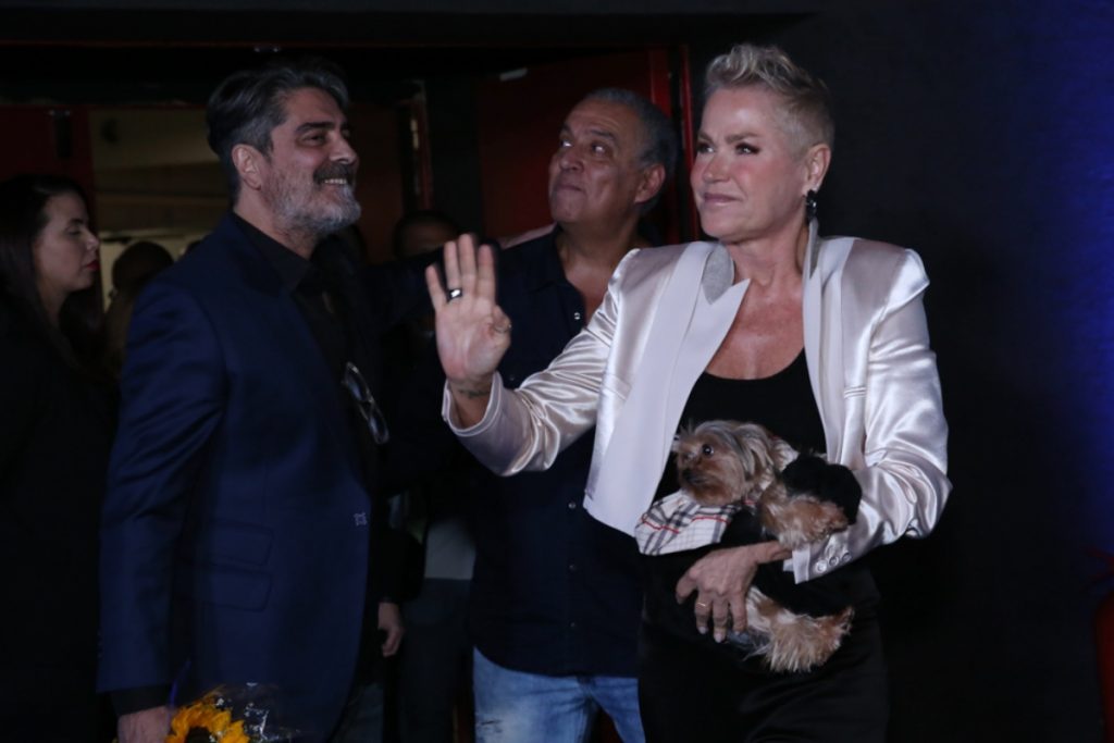 Xuxa chegando ao lançamento do documentário com Doralice no colo 