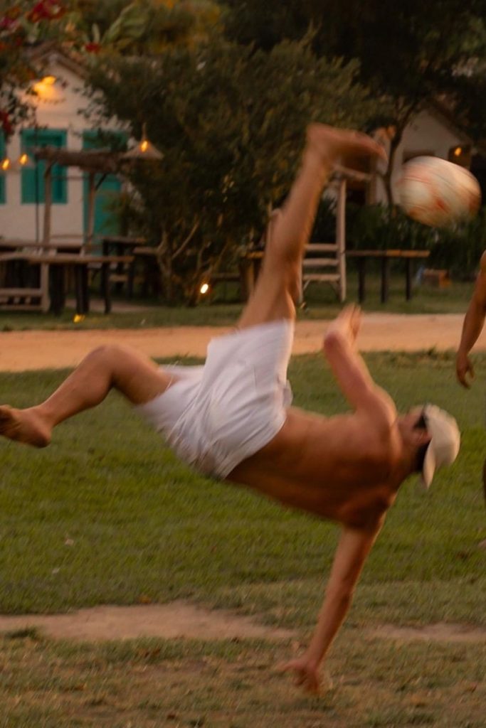 José Loreto sem camisa, de calção branco, jogando bola 