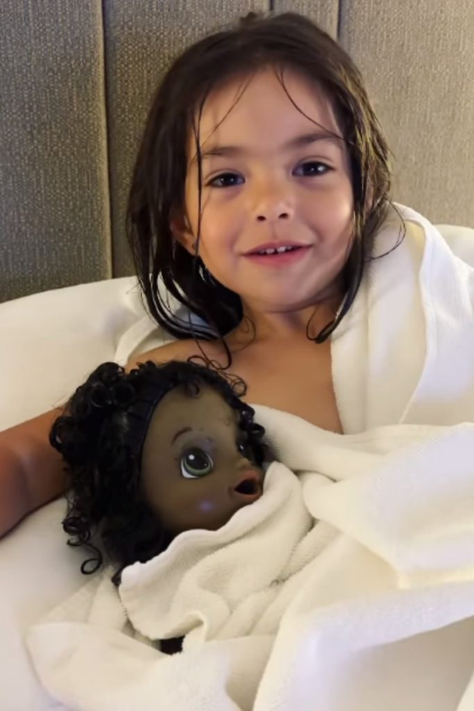 Zoe deitada com boneca