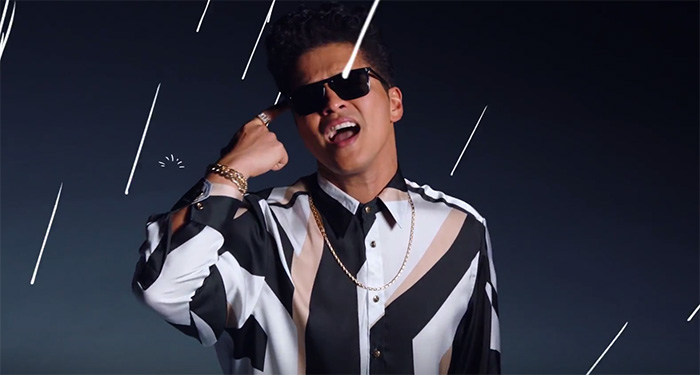 Bruno Mars de óculos escuros, camisa preta e branca 