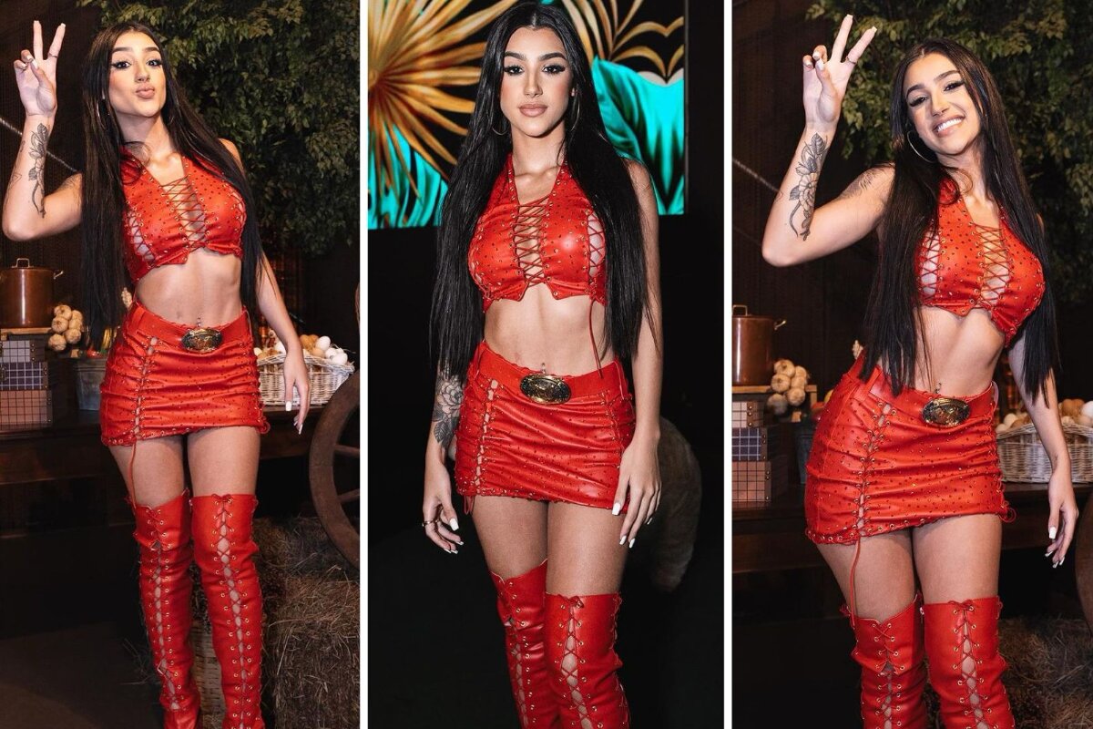 Bia Miranda de vermelho mandando beijo e fazendo sinal de positivo