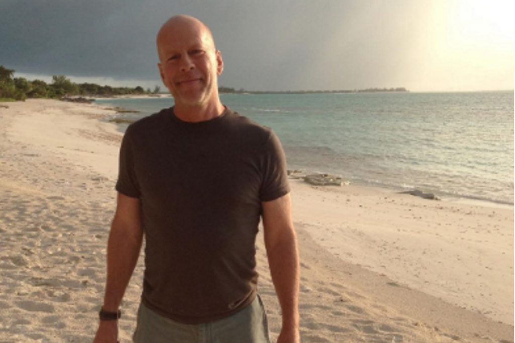 Bruce Willis caminhando na praia