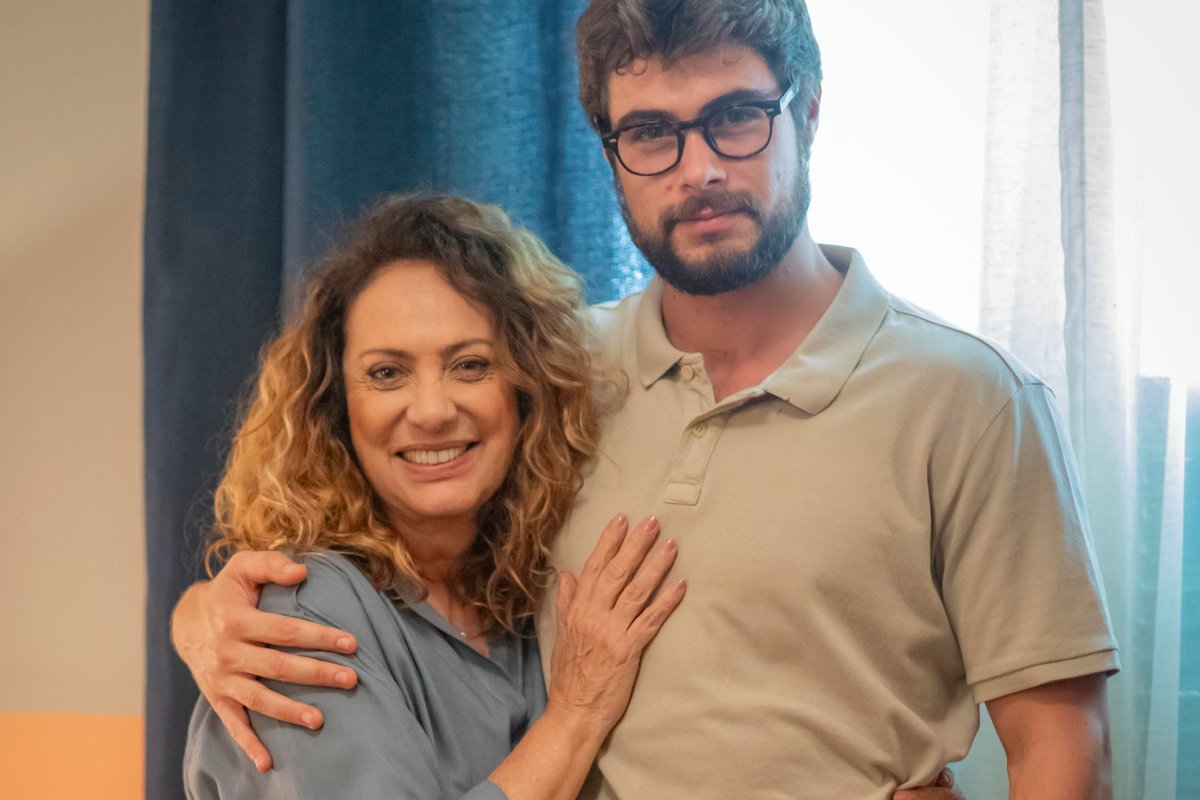 Agatha (Eliane Giardini) e Hélio (Rafael Vitti) abraçados em "Terra e Paixão"