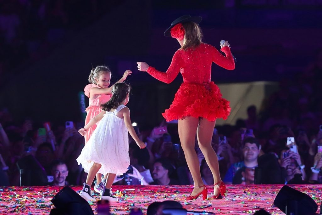 Ivete Sangalo de vermelho com as filhas gêmeas Helena e Marina, no palco 