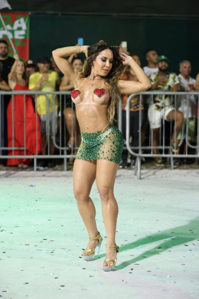 Mulher Melão de saia verde transparente e adesivo vermelho nos seios 