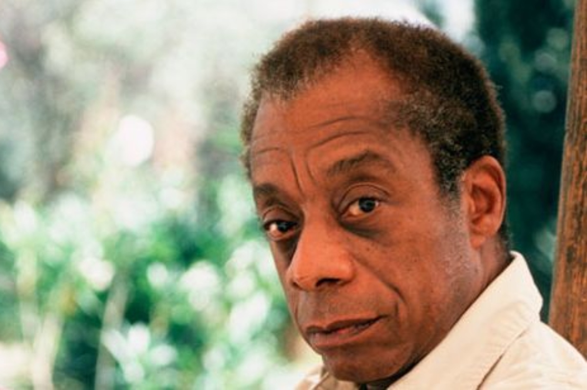 James Baldwin, olhando de lado, de camisa branca