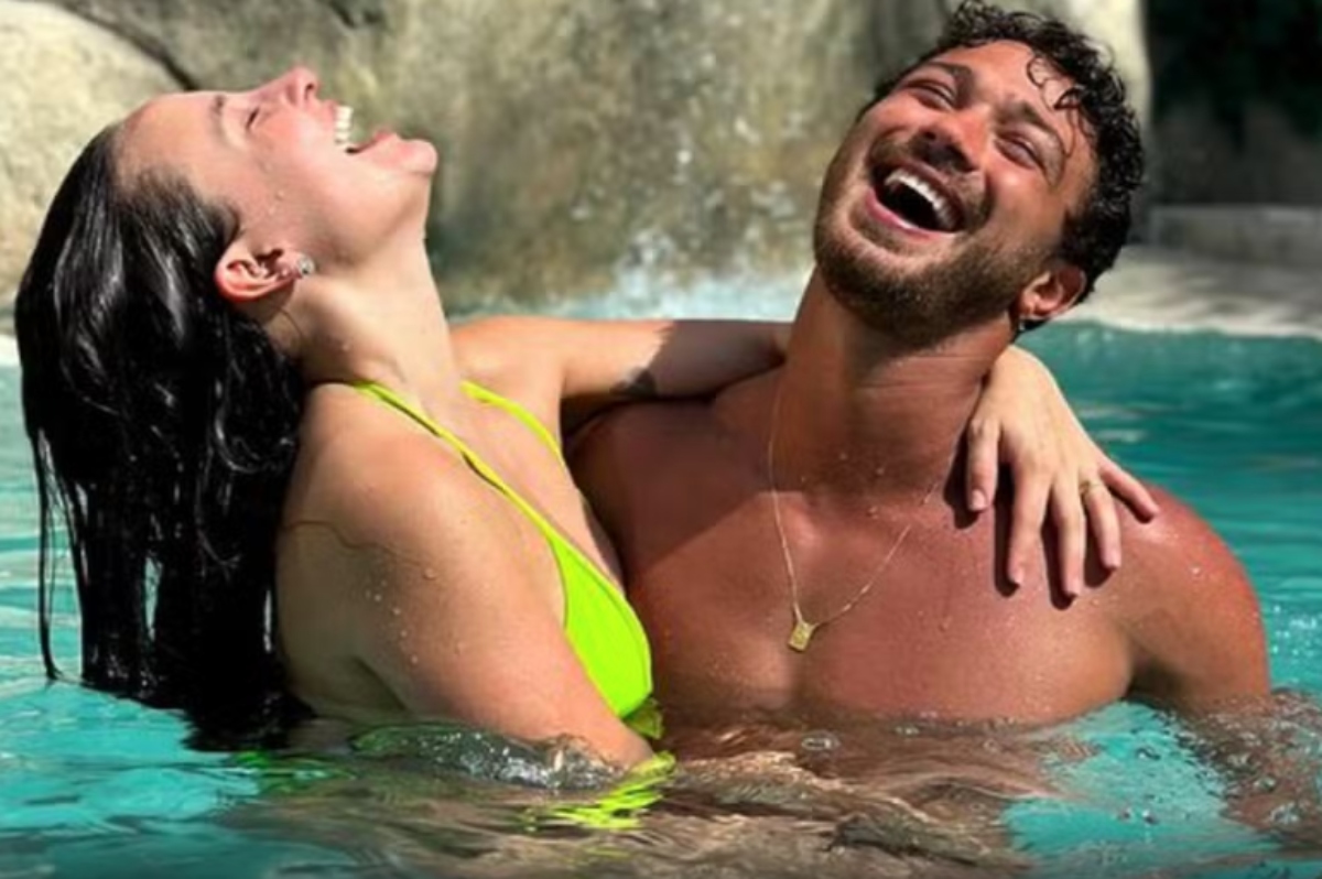 Larissa Manoela e André Luiz Frambach abraçados numa cachoeira, sorrindo