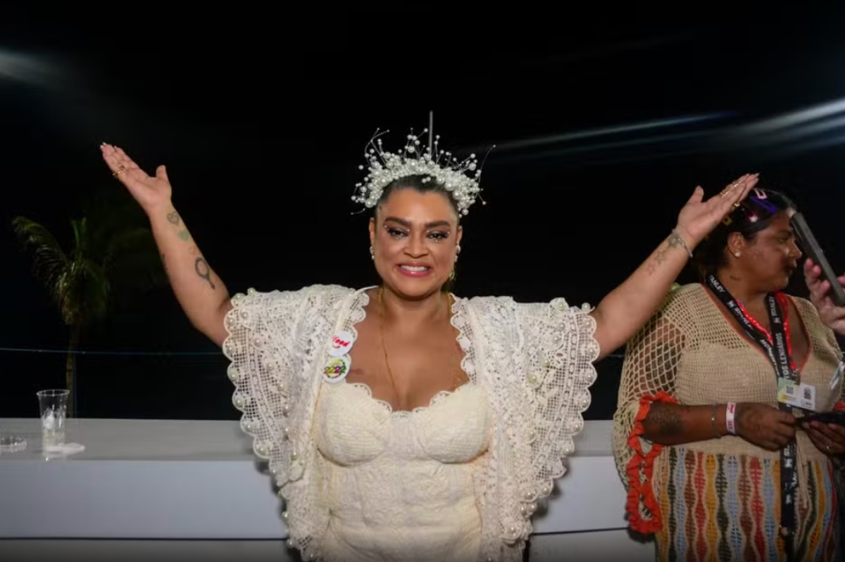 Preta Gil de vestido branco e coroa na cabeça, de braços abertos, no Carnaval de Salvador